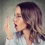 five-ways-to-fight-bad-breath-featured-image-woman-breathing-into-her-hand