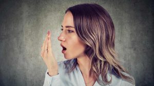 five-ways-to-fight-bad-breath-featured-image-woman-breathing-into-her-hand